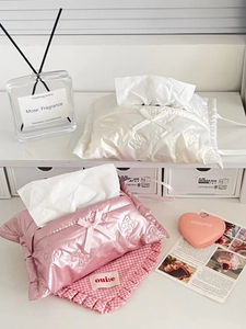 Detail of pink and white padded tissue boxes with bow accents and pearl finish