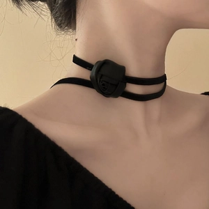 Detail shot of a black fabric rose choker necklace on model showing elegant neck lines