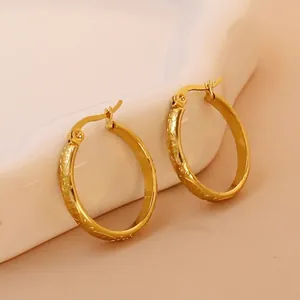 Close-up of 18K gold plated earrings with vintage dragon scale embossed textures