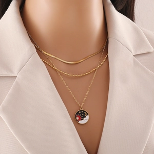 Dreilagige goldene Stern- und Mondkette auf beigem Blazer für einen edlen Look