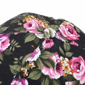 Top view detail of black cotton baseball cap featuring pink rose floral print and top button