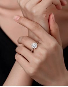 Close-up of a flower-shaped moissanite ring in S925 sterling silver on a finger
