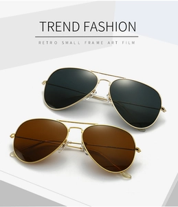 Detail of pilot sunglasses with gold metal frames and gradient black and brown lenses