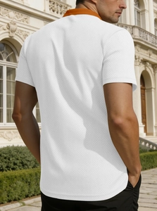 Vue détaillée du dos d'un polo en coton piqué blanc avec col contrasté orange élégant