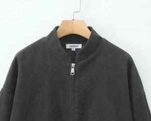 Detail of black corduroy jacket fabric texture on wood hanger with size M neck label