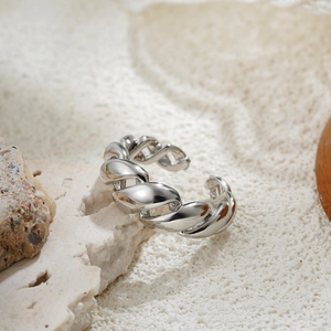 Macro shot of silver twisted metal open ring displayed on a natural textured stone base