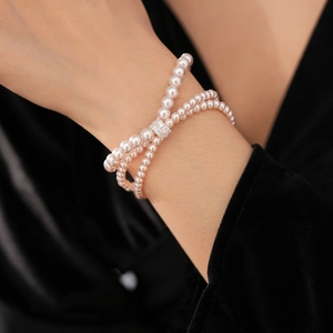 Detailed view of triple-layered pearl bracelet with a sparkling zircon-studded metal clasp