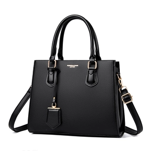 Minimalist black lychee pattern leather tote bag with detachable shoulder strap and charm