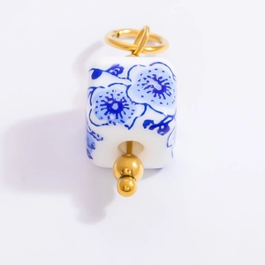 Detail of square blue and white porcelain pendant with 18k gold plated metal accents
