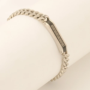 Detail of silver Cuban link bracelet featuring a black enamel Greca pattern plate