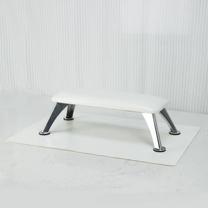 Detail of white leather nail hand rest with silver metal legs for manicure support