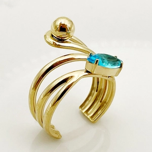 Golden chain ring with oval blue gemstone and triple-layered wrap design on white background