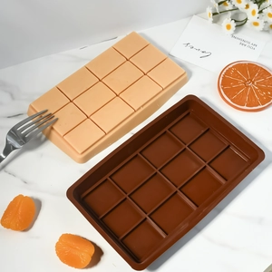 Detalle de moldes de silicona para chocolate de 12 cavidades en marrón y rosa sobre mármol