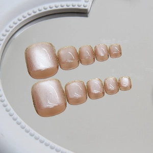 French cat eye press-on toenails with nude base and sparkling gold glitter gradient tips