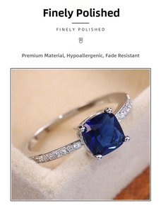 Macro shot of square blue zircon ring with paved diamonds in beige jewelry box