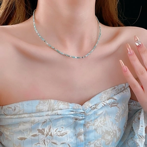 Detail of beaded Amazonite choker with silver spacers on a fashion model's collarbone