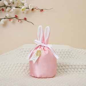Pink velvet bunny ear gift bag with golden Xi pendant and white thank you label
