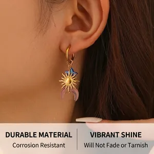 Detailed close-up of a gold hoop earring featuring celestial moon and star charms