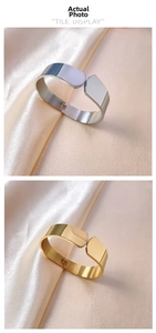 Macro view of gold and silver stainless steel bangles with geometric cut on silk
