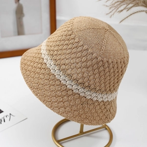 Japanese style straw bucket hat in light brown with white stripe on a metal display stand