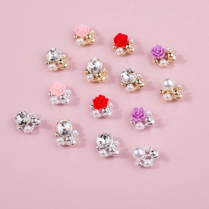 Mixed set of 13 camellia flower and pearl nail art charms with rose designs on pink background