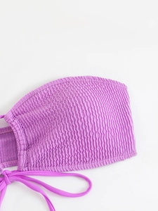 Detail shot of purple smocked bikini top with elastic texture and tie string