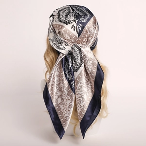 Close-up of dual-tone paisley silk scarf tied as a headband on a professional mannequin