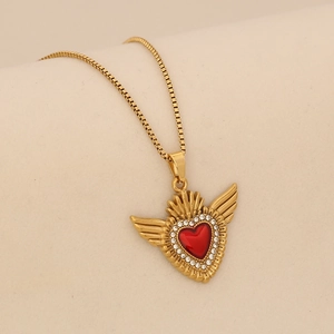 Détail du pendentif cœur avec pierre rouge, ailes et chaîne box dorée raffinée