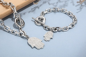 Detail of silver Hamsa hand pendant on stainless steel necklace and bracelet set