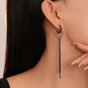 Close-up of model wearing black geometric fringe earrings with rhinestones