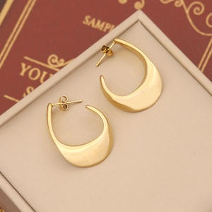 Macro view of polished gold chunky teardrop hoop earrings on a vintage jewelry gift box