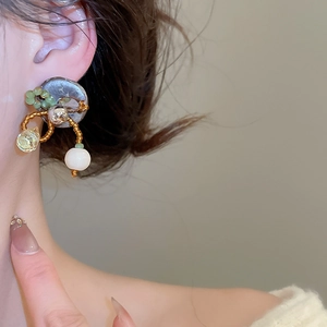 Vue détaillée de boucles d'oreilles vintage ethniques avec perles vertes et pendentif
