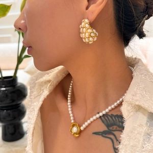Retro hollow drop pearl earrings and necklace set with golden flower pendant on model