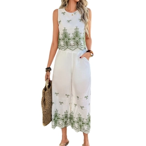 Women's white two-piece set featuring sleeveless top with green embroidery and wide-leg pants