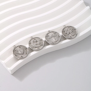 Macro shot of silver titanium pendants with moon, sun, cross and tree of life engravings
