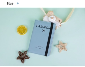 Blaue Reisepasshülle mit Flugzeugmotiv und Gummiband auf minzgrünem Hintergrund