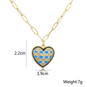 Detail view of 18K gold heart pendant with blue enamel and zircon, 2.2cm x 1.9cm size