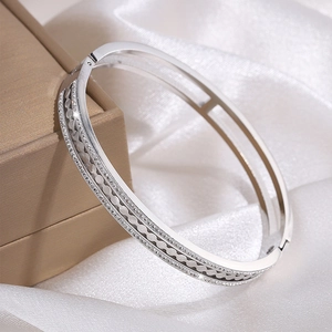 Detail of silver hollow wave bangle with zircon inlay on soft silk fabric and jewelry box