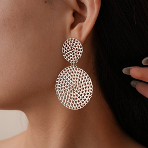Gros plan détaillé d'un mannequin portant des boucles d'oreilles créoles tissées
