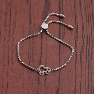 Bracelet coeur ajustable en acier inoxydable au design ajouré sur fond en cuir sombre