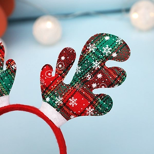 Détail de bois de renne à carreaux rouges et verts avec motif de flocon sur le serre-tête Noël