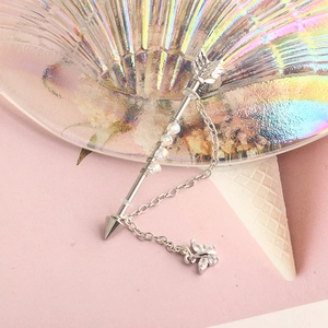 Detailed view of silver arrow industrial barbell with rainbow beads and butterfly chain