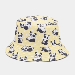 Detail view of yellow bucket hat with cartoon panda patterns and white polka dots
