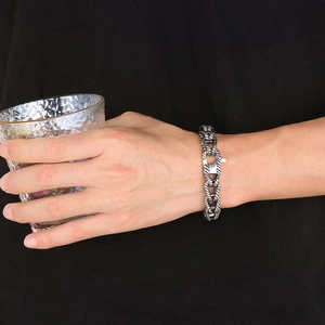 Detail of a chunky stainless steel Cuban link bracelet for men on model's wrist