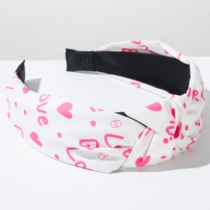 Detailed view of the fabric headband knot featuring pink hearts and love lettering print