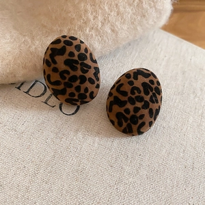 Close-up of oval leopard print earrings with a flocked texture for autumn style