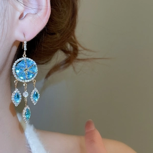 Macro shot of French vintage earring with blue sapphire crystal and snowflake tassel detail