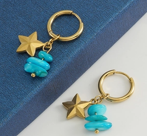 Dettaglio degli orecchini a cerchio dorati con ciondoli a stella e pietre blu naturali