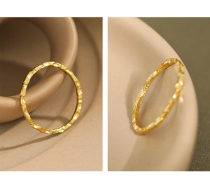 Detail of minimalist gold textured ring showing the irregular hammered finish and thin band