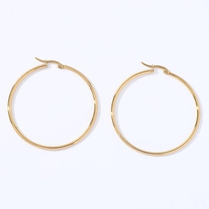 Close-up of oversized polished gold geometric round hoop earrings with minimalist style